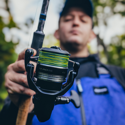 Angler holding a rod with the Shimano Aero BB C5000 reel, featuring green line and a sturdy build for reliable performance.